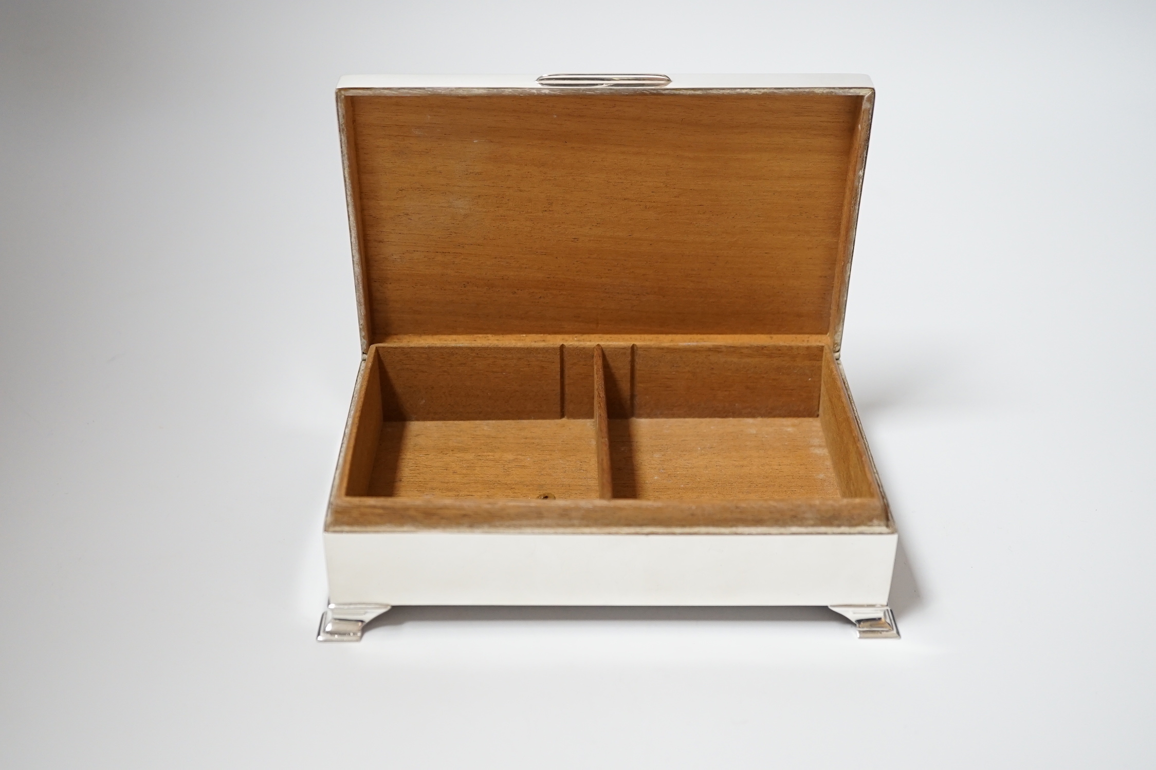 An Elizabeth II engine turned silver mounted rectangular cigarette box, Birmingham, 1961, 15.4cm, on bracket feet.